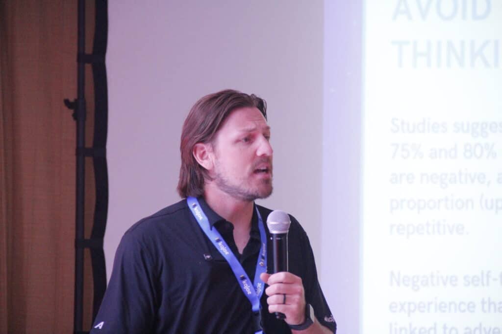 Close-up of Bobby Macey speaking at the Kajae Summit in Cancún 2025, highlighting the importance of avoiding negative thinking during his keynote session.